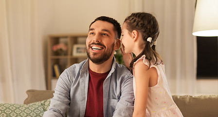 Image showing happy daughter whispering secret to father at home