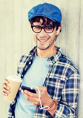 Image showing man with earphones and smartphone drinking coffee