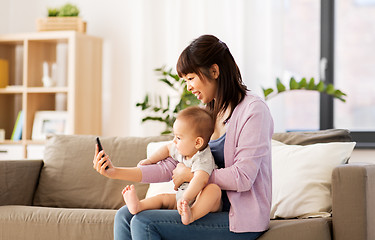 Image showing asian mother with baby son taking selfie at home