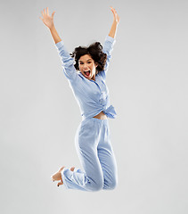 Image showing happy woman in blue pajama jumping high