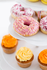 Image showing close up of glazed donuts and cupcakes on stand