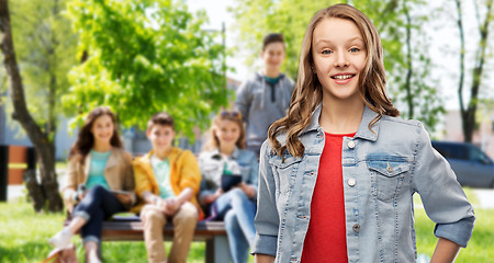 Image showing smiling teenage girl in denim jacket over friends