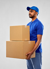 Image showing indian delivery man with parcel boxes in blue