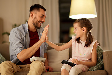 Image showing father and daughter playing video game at home