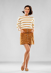 Image showing young woman in striped pullover, skirt and shoes