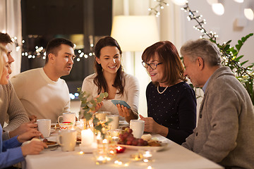 Image showing happy family with smartphone at tea party at home