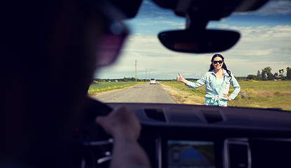 Image showing woman hitchhiking and stopping car with thumbs up