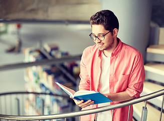 Image showing student boy or young man reading book at library