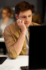 Image showing tired or bored man on table at night office