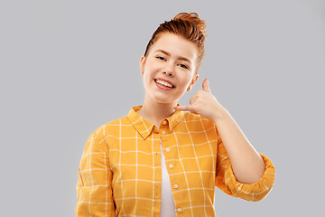 Image showing redhead teenage girl making phone call gesture
