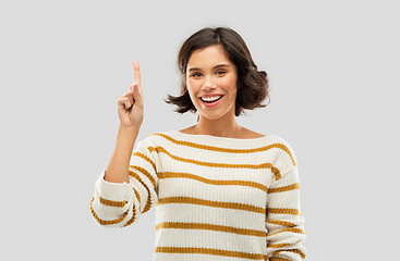 Image showing happy woman showing one finger or pointing up