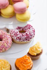 Image showing close up of glazed donuts and cupcakes on stand