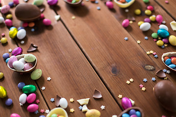 Image showing chocolate eggs and candy drops on wooden table