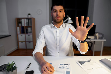 Image showing businessman using gestures at night office