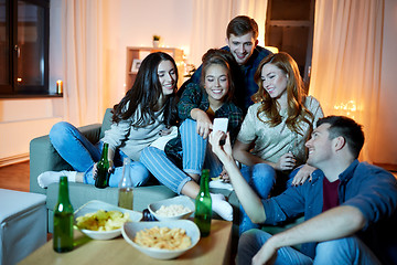 Image showing happy friends with smartphone at home party