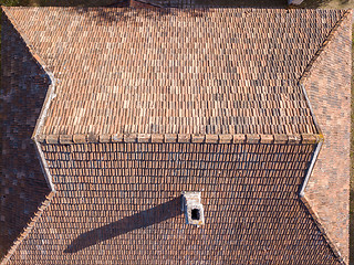 Image showing Top view of tile roof with chimney and shadows.