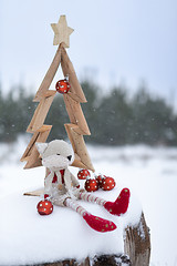 Image showing Simple Christmas tree in snow with baubles and christmas decorat