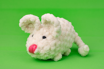Image showing White knitted mouse, made with its own hands, on a green background