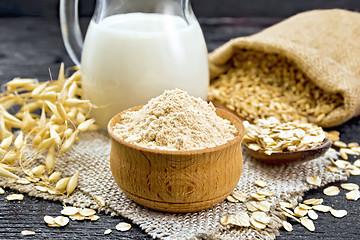 Image showing Flour oat in bowl on dark wooden board