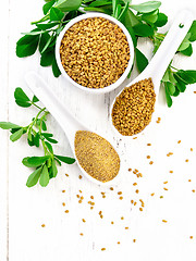 Image showing Fenugreek in two spoons and bowl with leaves on board top