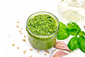 Image showing Pesto in jar on wooden board