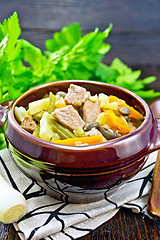 Image showing Soup Eintopf in clay bowl on wooden board