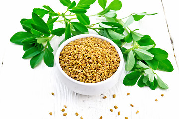 Image showing Fenugreek with green leaves in bowl on board