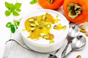 Image showing Dessert of yogurt and persimmon in bowl on light board