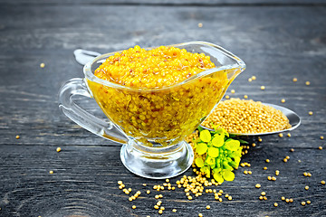 Image showing Sauce mustard Dijon in sauceboat with flower on board