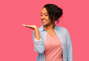 Image showing happy african woman holding something on hand