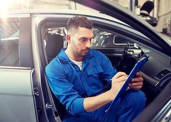 Image showing auto mechanic man with clipboard at car workshop