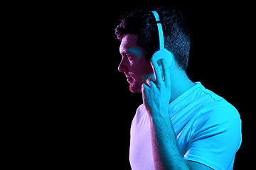 Image showing man in headphones over neon lights of night club