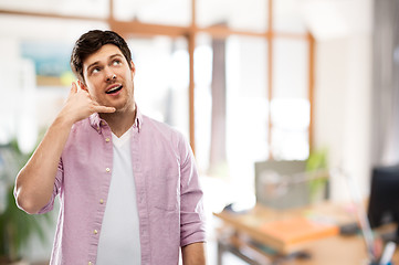 Image showing man showing phone call gesture over office room