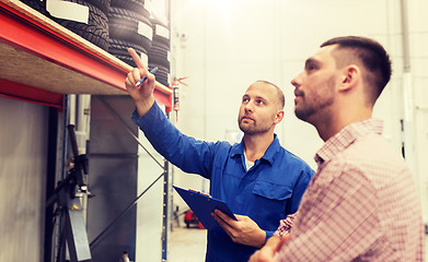 Image showing auto mechanic with clipboard and man at car shop