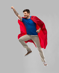 Image showing man in red superhero cape flying in air