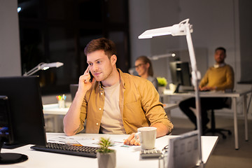 Image showing man calling on smartphone at night office