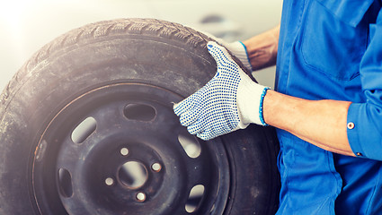 Image showing mechanic with wheel tire at car workshop