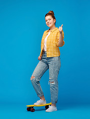 Image showing teenage girl with skateboard showing thumbs up