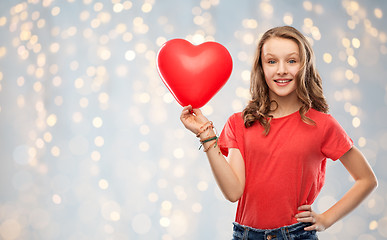 Image showing smiling teenage girl with red heart shaped balloon