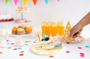 Image showing hand putting piece of birthday cake on plate