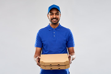 Image showing happy indian delivery man with pizza boxes in blue