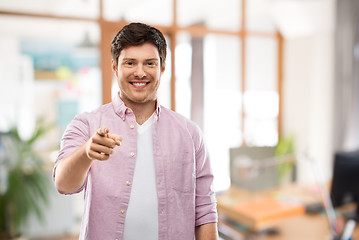 Image showing smiling man pointing fingers at you over office