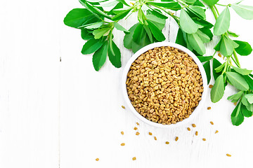 Image showing Fenugreek with green leaves in bowl on board top