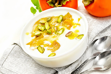 Image showing Dessert of yogurt and persimmon in bowl on board