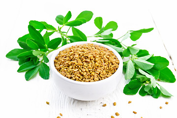 Image showing Fenugreek with green leaves in bowl on wooden board