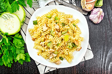 Image showing Fusilli with chicken and zucchini in plate on wooden board top