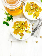 Image showing Dessert of yogurt and persimmon two bowls on light board top