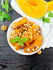 Image showing Pumpkin with nuts and honey on wooden board top