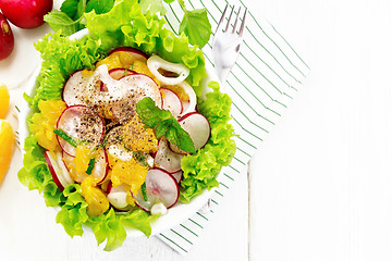 Image showing Salad of radish and orange with mint on light board top