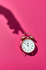 Image showing Shadow\'s hand presses above alarmclock.